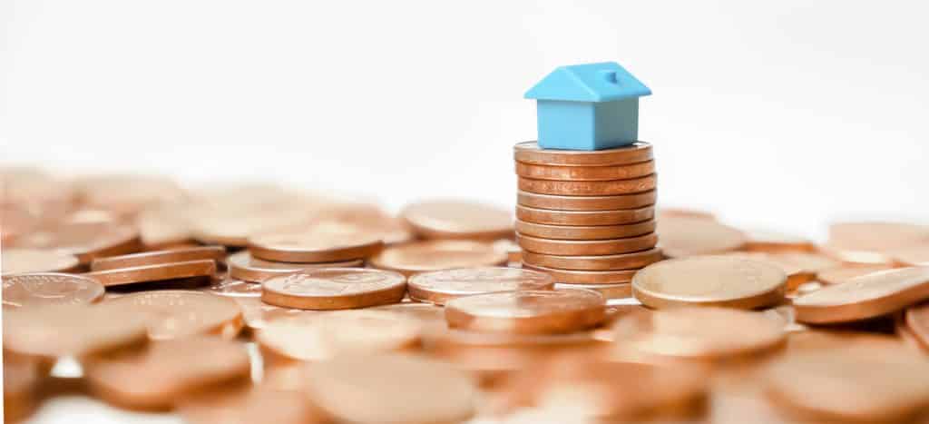 Property banner home money coins tower profit real estate investment or household income rate. Miniature home model on stack coins building money house loan property value time rent or buy real estate