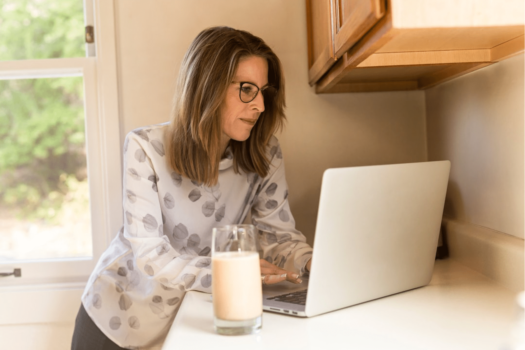 A female professional working from home, utilizing data analysis for effective lead qualification through a targeted selling strategy