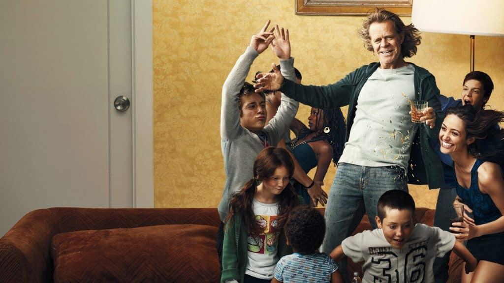 Extras For Shameless: Catch the Final Season of Shameless! A group of people joyfully dance and laugh together in a living room.